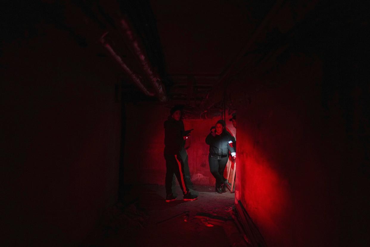 Ukrainian Emergency Situation employees stand in a shelter during Russian shelling, in Mariupol, Ukraine, Thursday, Feb. 24, 2022. Russia launched a wide-ranging attack on Ukraine on Thursday, hitting cities and bases with airstrikes or shelling, as civilians piled into trains and cars to flee. Ukraine's government said Russian tanks and troops rolled across the border in a “full-scale war” that could rewrite the geopolitical order and whose fallout already reverberated around the world. (AP Photo/Evgeniy Maloletka)