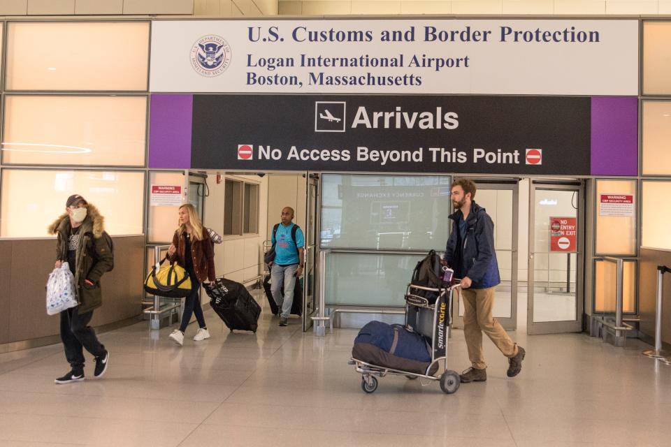 Passengers leave the secure area in the arrivals area of the international terminal at Logan Airport on March 13, 2020 in Boston, Massachusetts.