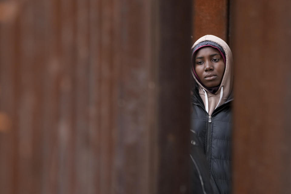 A migrant woman waits between two border walls hoping to apply for asylum, a day after the Title 42 cutoff, as seen from San Diego, May 12, 2023. Mexico is flying migrants south away from the U.S. border to keep migrants from massing in its border cities. (AP Photo/Gregory Bull)