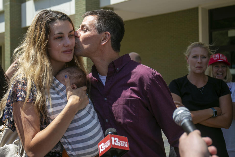 Michigan gubernatorial candidate Ryan Kelly kisses his wife Tabitha Kelly after leaving the U.S. District Court in Grand Rapids, Mich., with his family and supporters on Thursday, June 9, 2022. Kelley has been charged with four misdemeanors from his involvement with the riot at the Capitol Building in Washington, D.C., on Jan. 6, 2021. (Daniel Shular/The Grand Rapids Press via AP)