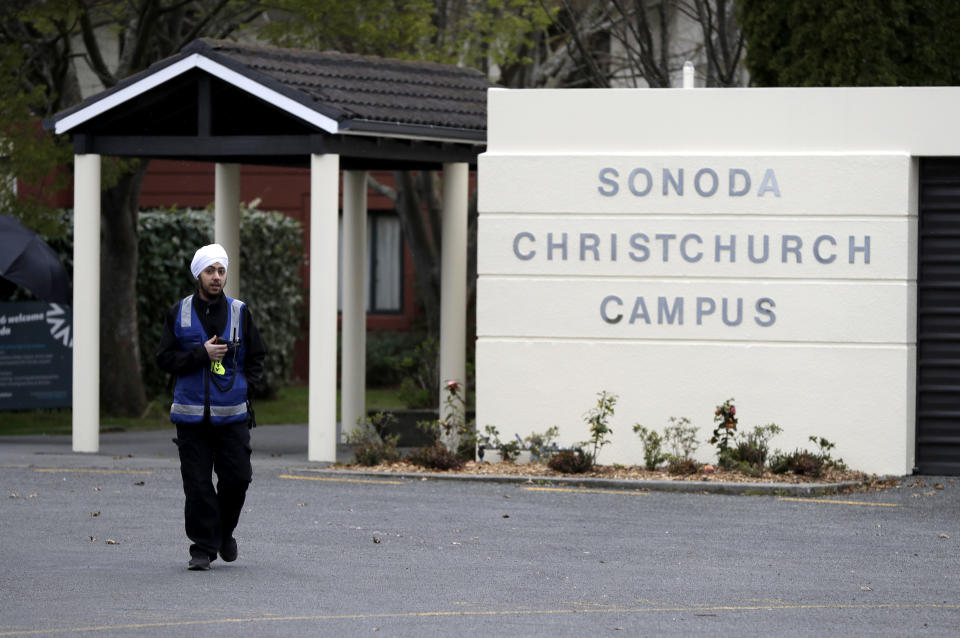 A security guard keeps watch outside student accommodation at Canterbury University in Christchurch, New Zealand, Wednesday, Sept. 25, 2019. New Zealand's education minister called for an investigation Wednesday after reports that a student's body lay undiscovered in a university dorm room for nearly eight weeks. (AP Photo/Mark Baker)