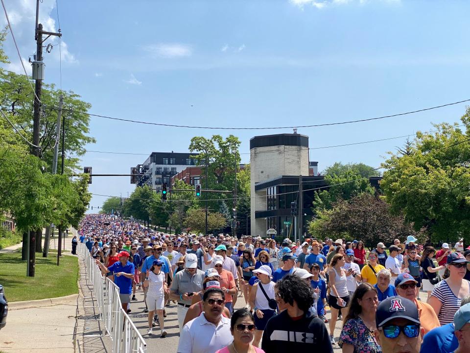 Thousands of people join a community walk in downtown Highland Park, Illinois, on July 4, 2023.