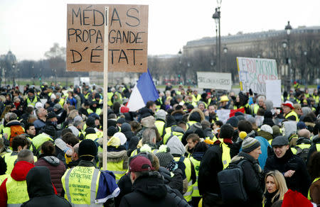 Protesters wearing yellow vests take part in a demonstration by the "yellow vests" movement, in Paris, France, January 19, 2019. The sign reads "Media State Propaganda". REUTERS/Charles Platiau