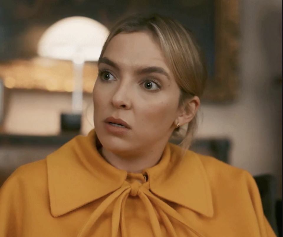 a blonde woman wearing a yellow blouse