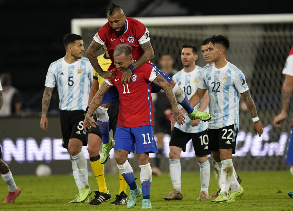 Chile's Eduardo Vargas, center below, celebrates scoring his side's first goal against Argentina with teammate Arturo Vidal during a Copa America soccer match at the Nilton Santos stadium in Rio de Janeiro, Brazil, Monday, June 14, 2021. (AP Photo/Ricardo Mazalan)