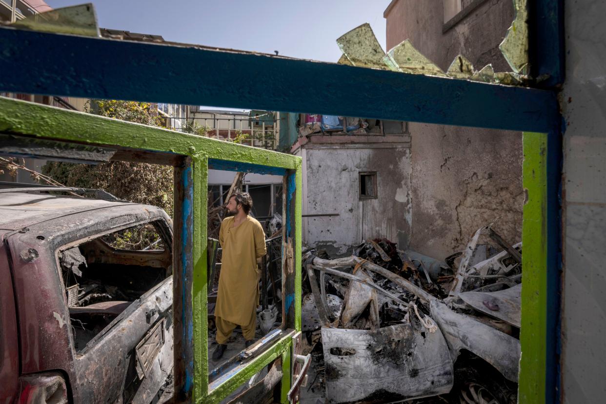 In this photo from Monday, an Afghan inspects the damage of the Ahmadi family house in Kabul.