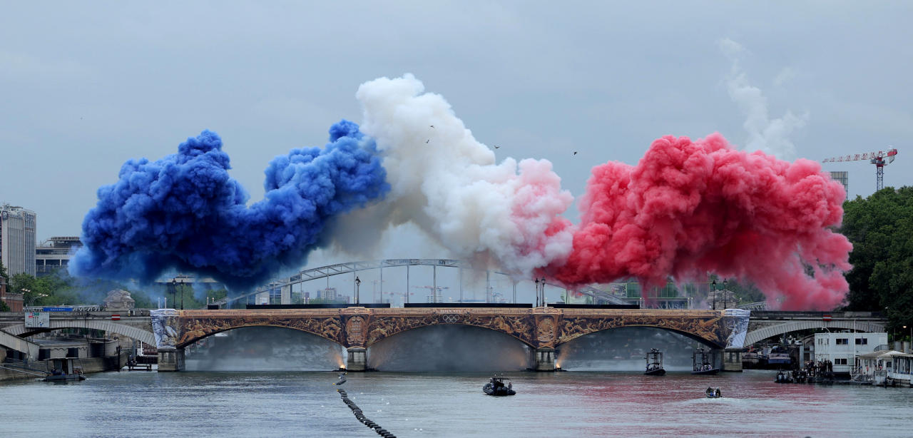 PARIS, FRANCE - JULY 26: Smoke clouds in the tricolours of the France flag are seen at Pont d'Austerlitz during the Opening Ceremony of the Olympic Games Paris 2024 on July 26, 2024 in Paris, France. (Photo by Ann Wang - Pool/Getty Images)