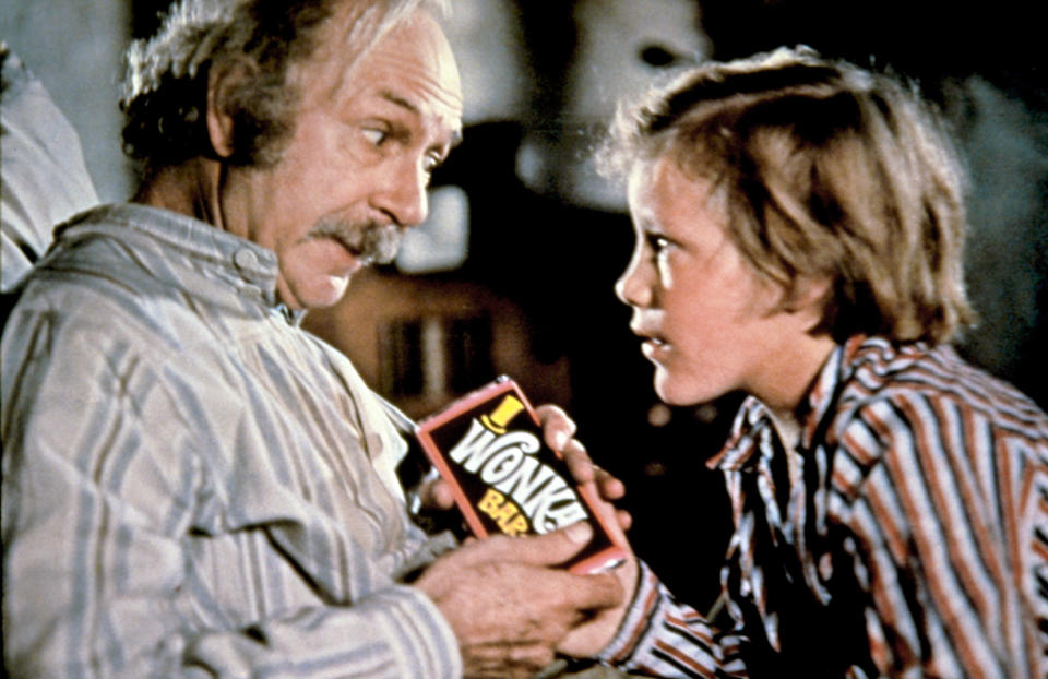 A man and his grandson sit, looking at a chocolate bar