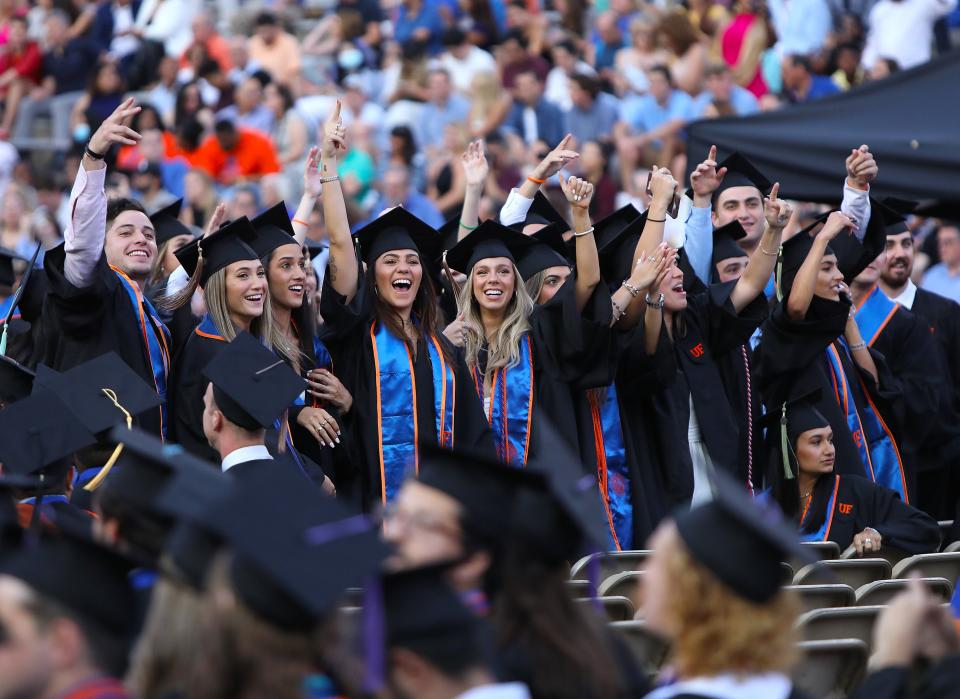 University of Florida graduates cheer for the cameras during the Spring 2022 Commencement Ceremony being held at Ben Hill Griffin Stadium, in Gainesville Fla. April 29, 2022. Florida Gators great Tim Tebow was the commencement speaker. He talked about not just being successful, but being sure that you were being significant.