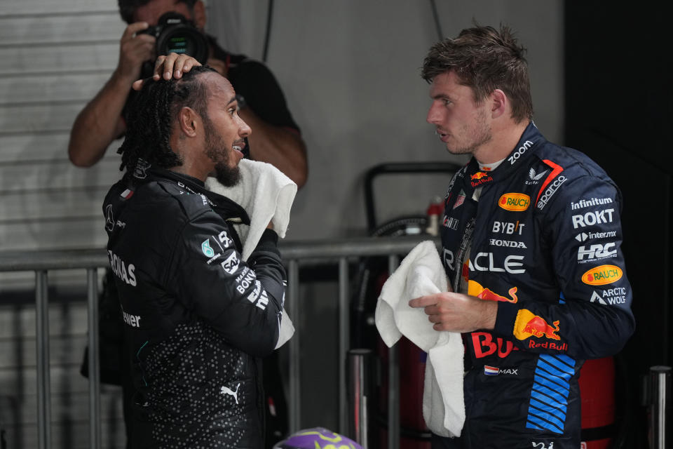 Second placed Red Bull driver Max Verstappen of the Netherlands, right, talks with third placed Mercedes driver Lewis Hamilton of Britain after qualifying session of the Singapore Formula One Grand Prix at the Marina Bay Street Circuit, in Singapore, Saturday, Sept. 21, 2024. (AP Photo/Vincent Thian)