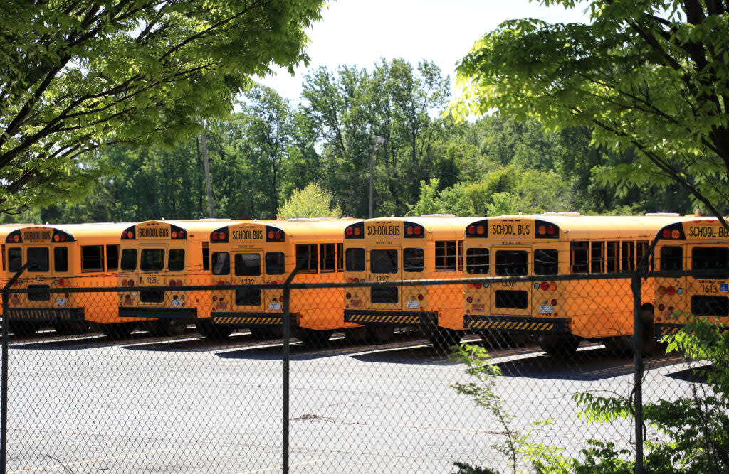 School buses are parked inside a fenced lot