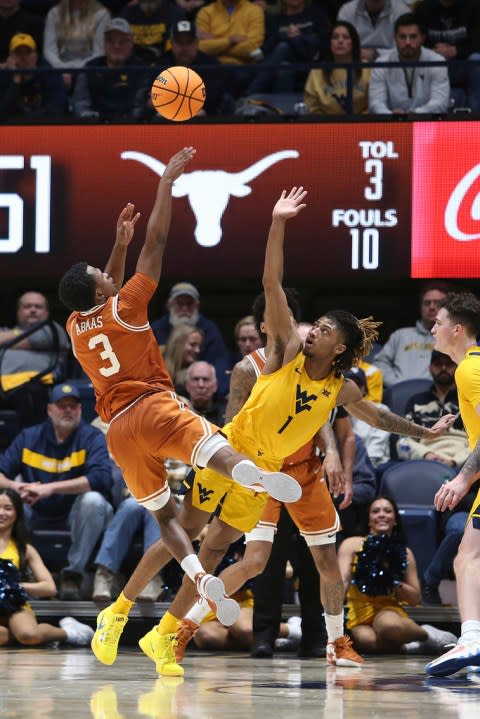 Texas guard Max Abmas (3) is defended by West Virginia guard Noah Farrakhan (1) during the second half of an NCAA college basketball game on Saturday, Jan. 13, 2024, in Morgantown, W.Va. (AP Photo/Kathleen Batten)