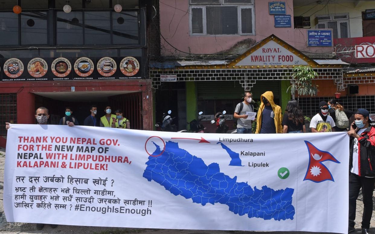 Citizens hold up a banner displaying the new map in Kathmandu - PRAKASH MATHEMA/AFP