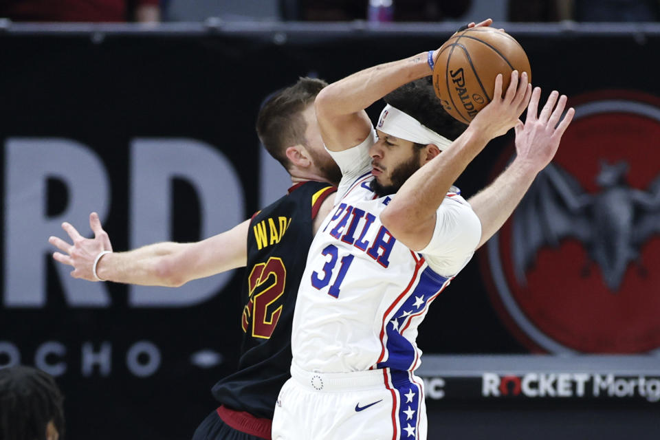 Philadelphia 76ers' Seth Curry (31) grabs a rebound against Cleveland Cavaliers' Dean Wade (32) in the first half of an NBA basketball game, Thursday, April 1, 2021, in Cleveland. (AP Photo/Ron Schwane)