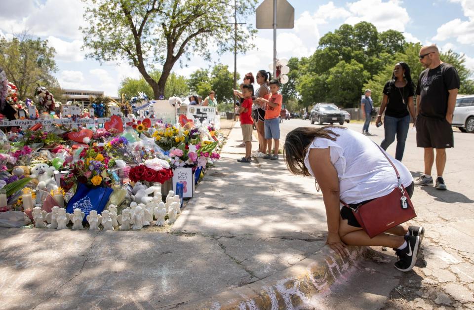 A woman kneels at a memorial on Wednesday for the students and teachers who died in a mass shooting last week at Robb Elementary School in Uvalde.