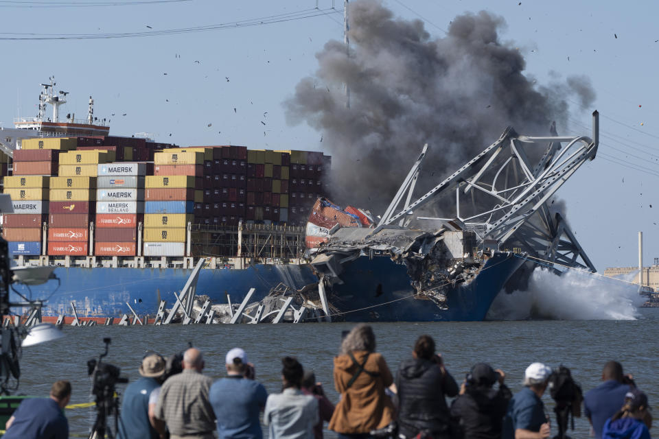 Explosive charges are detonated to bring down sections of the collapsed Francis Scott Key Bridge resting on the container ship Dali on Monday, May 13, 2024, in Baltimore. (AP Photo/Mark Schiefelbein)