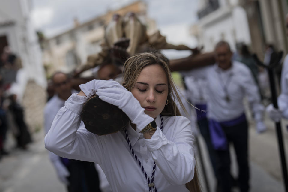 A member of the "Vera Cruz" Catholic brotherhood carries a figure of Jesus Christ during a Holy Week procession in the southern town of Quesada, Spain, Friday, March 29, 2024. (AP Photo/Bernat Armangue)