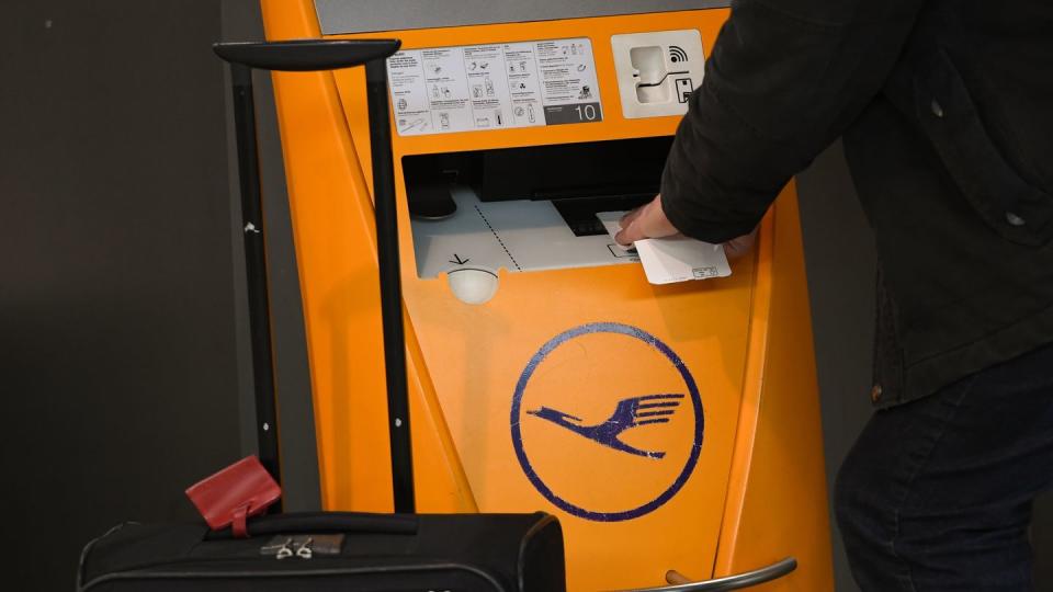 Ein Flugreisender scannt am Flughafen Frankfurt am Main sein Ticket an einem Check-in-Terminal der Lufthansa.