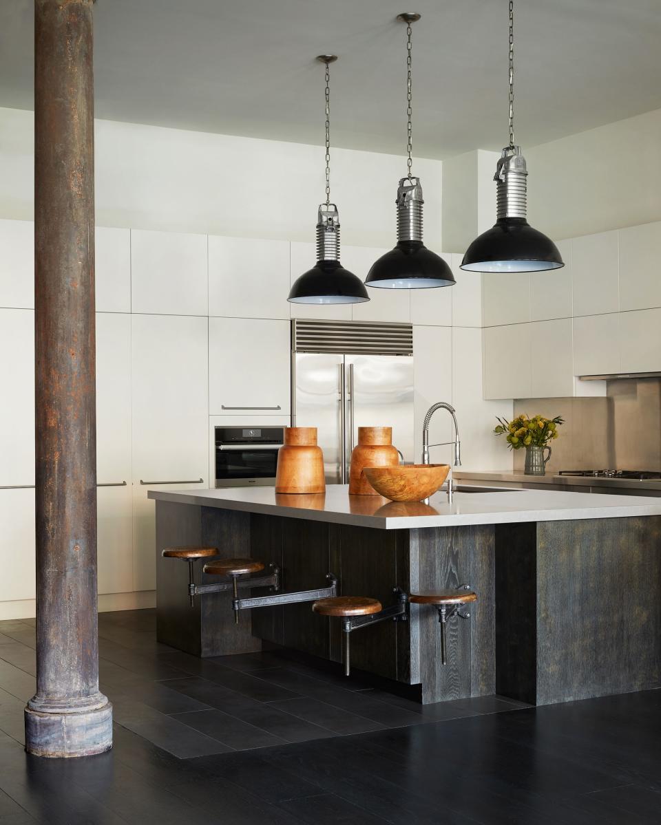 “I wanted something that wouldn’t be destroyed when friends come over,” says Liebman of his kitchen, where a cement-inspired Caesarstone-topped shou sugi ban island complements the minimalist stainless-steel backsplash. Vintage Philips pendants from the 1950s complete the space.