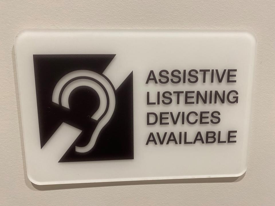 A courthouse sign advertises assistance for the hearing-impaired.