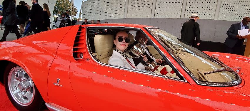 a man in a red convertible car