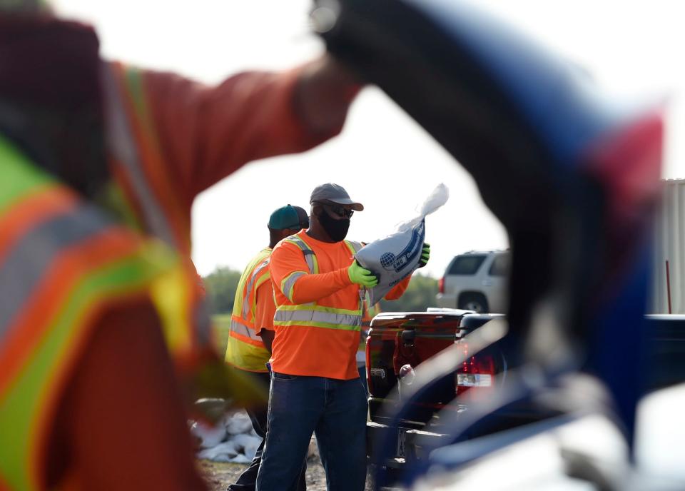 Residents pick up free sandbags ahead of Tropical Storm Beta, Saturday, Sept. 19, 2020, at J.C. Elliot Transfer Station and Collection Center. Due to COVID-19 concerns, drivers and passengers were asked to wear a mask and not exit their vehicle during loading. 