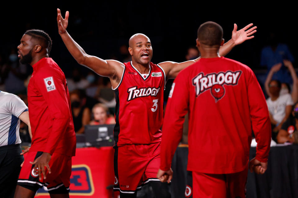 A Big3 play on the Trilogy team stands with his arms wide open to embrace his teammate.