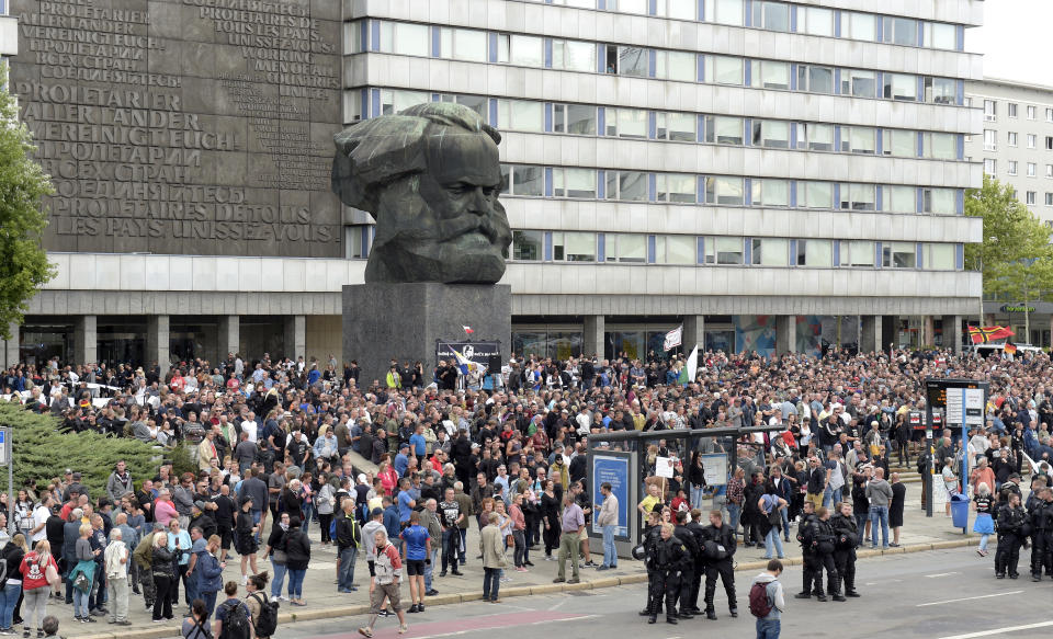 Protesters gather for a far-right protest in front of a Karl Marx monument in Chemnitz, Germany, Monday, Aug. 27, 2018 after a man has died and two others were injured in an altercation between several people of "various nationalities" in the eastern German city of Chemnitz on Sunday. (AP Photo/Jens Meyer)