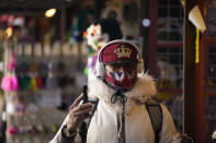 A man wears a Union flag face mask to curb the spread of coronavirus as he walks past stalls in a Christmas market, in Trafalgar Square, London, Monday, Nov. 29, 2021. Countries around the world slammed their doors shut again to try to keep the new omicron variant at bay Monday, even as more cases of the mutant coronavirus emerged and scientists raced to figure out just how dangerous it might be. In Britain, mask-wearing in shops and on public transport will be required, starting Tuesday. (AP Photo/Matt Dunham)