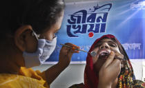 In this photo provided by Bidyanondo Foundation, a doctor examines a patient after arriving at Banishanta village near Mongla seaport in southwestern region of Bangladesh, Sept. 1, 2020. A Bangladeshi charity has set up a floating hospital turning a small tourist boat into a healthcare facility to provide services to thousands of people affected by this year's devastating floods that marooned millions. (Bidyanondo Foundation via AP)