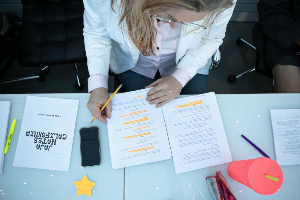 A person looks at a script at a table.