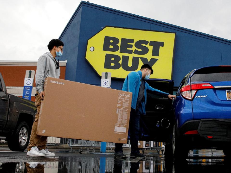 Customers load TV into back of SUV outside Best Buy store