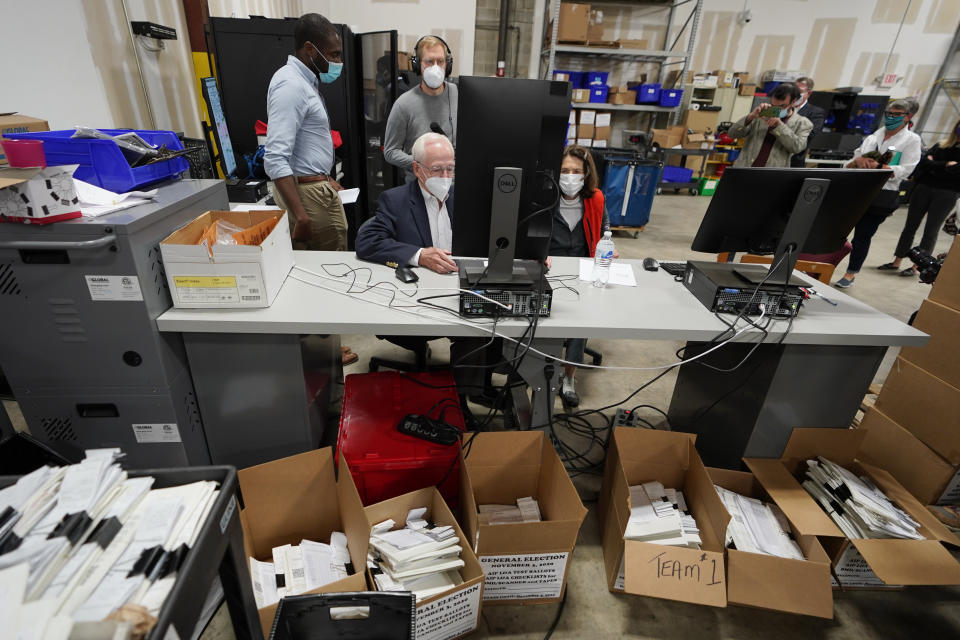 Democratic and Republican representatives review absentee ballots at the Fulton County Election preparation Center Wednesday, Nov. 4, 2020 in Atlanta. (AP Photo/John Bazemore)