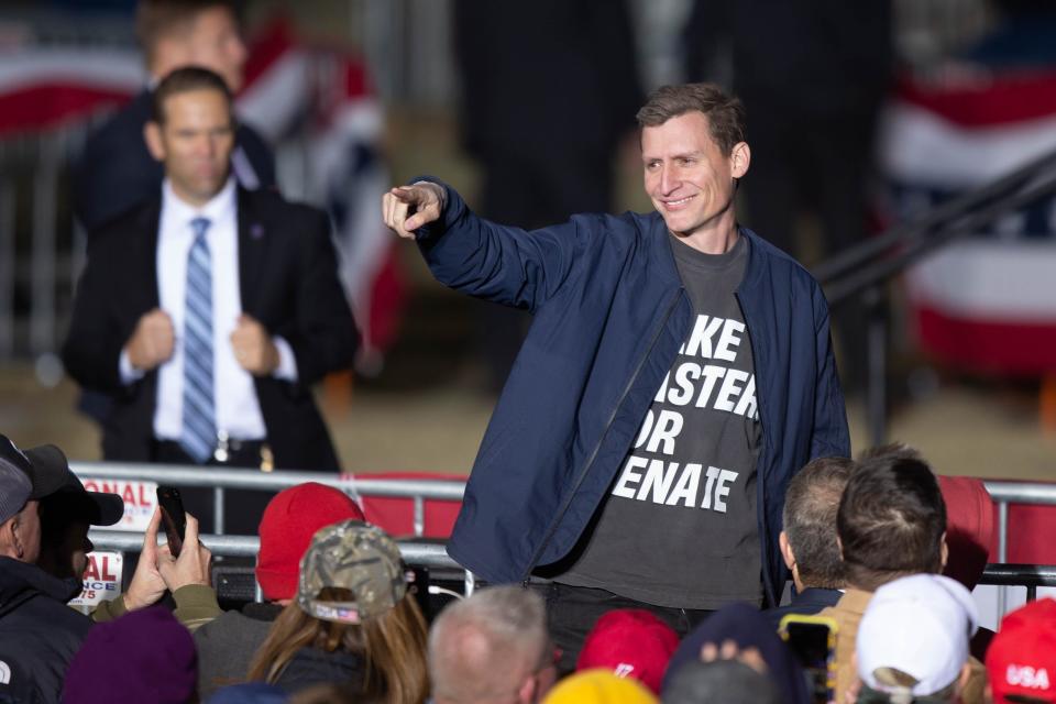 Blake Masters stands and points to the crowd during former President Donald Trump's speech at the Save America Rally in Florence on Jan. 15, 2022.