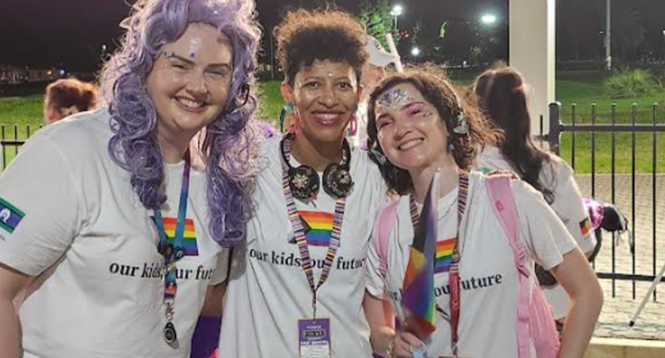 Elisha Benbow, pictured centre in a group of three, is from Kids Helpline.