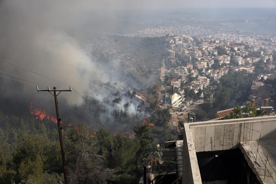 Flames burn trees on a hill during a wildfire in Voula suburb, in southern Athens, Greece, Saturday, June 4, 2022. A combination of hot, dry weather and strong winds makes Greece vulnerable to wildfire outbreaks every summer. (AP Photo/Yorgos Karahalis)