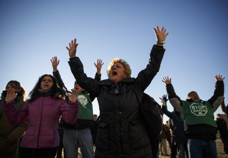 Anti-eviction activists shout slogans after a family was evicted from their apartment in Madrid