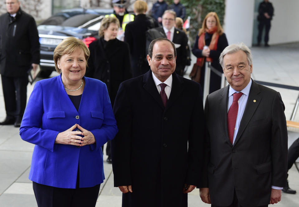 German Chancellor Angela Merkel, left, greets United Nations Secretary General Antonio Guterres, right, and Egypt's President Abdel Fattah al-Sisi, center, during arrivals for a conference on Libya at the chancellery in Berlin, Germany, Sunday, Jan. 19, 2020. German Chancellor Angela Merkel hosts the one-day conference of world powers on Sunday seeking to curb foreign military interference, solidify a cease-fire and help relaunch a political process to stop the chaos in the North African nation. (AP Photo/Jens Meyer)