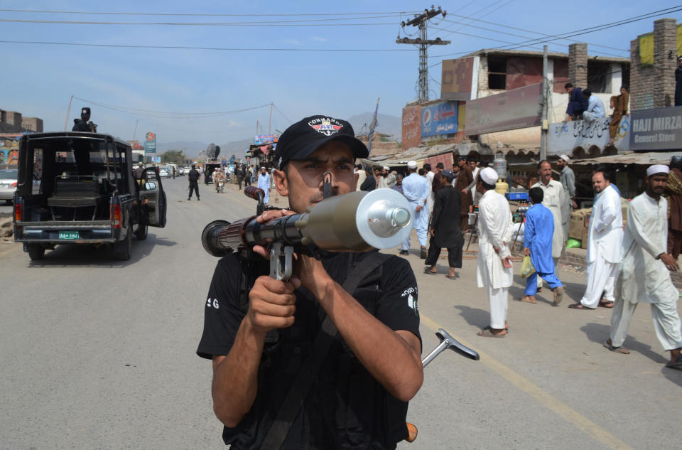 A Pakistani police commando stands guard near the scene where NATO trucks were attacked in the Pakistani tribal area of Jamrud near Peshawar, Pakistan, Monday, May, 5, 2014. A local Pakistani government official says militants have attacked a NATO supply convoy en route to Afghanistan, killing two drivers. (AP Photo/ Mohammad Sajjad)