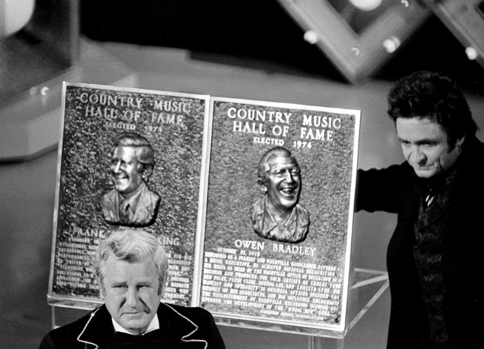 Pee Wee King, left, looks as he became the newest member of the Country Music Hall of Fame during the 8th annual CMA Awards show Oct. 14, 1974. Master of ceremonies Johnny Cash, right, called King "a flamboyant entertainer and the man who introduced drums and electric instruments of the Opry stage."