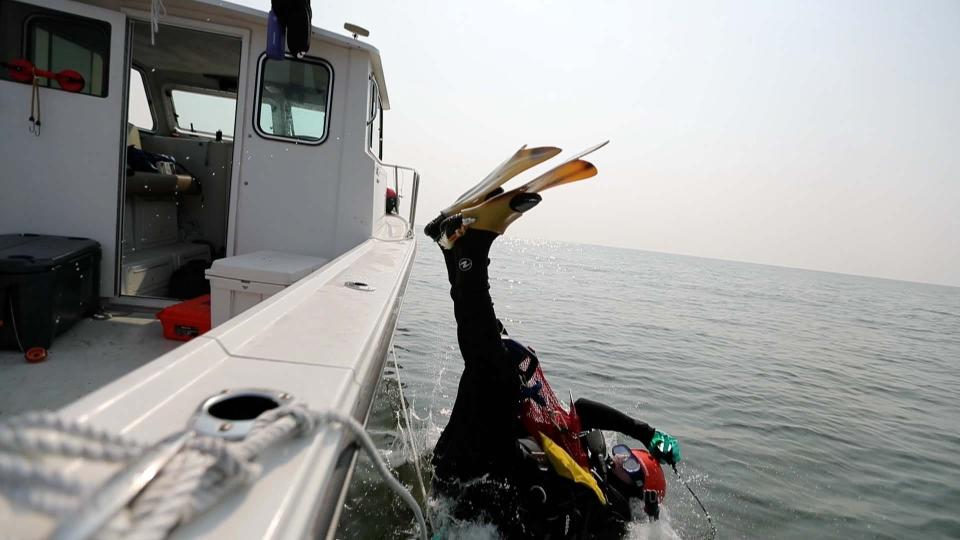 Bill Eberlein goes overboard as he dives for megalodon teeth near Savannah, Georgia.