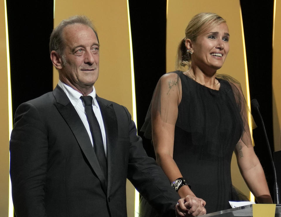 Vincent Lindon, left, and director Julia Ducournau accept the Palme d'Or for the film 'Titane' during the awards ceremony for the 74th international film festival, Cannes, southern France, Saturday, July 17, 2021. (AP Photo/Vadim Ghirda)