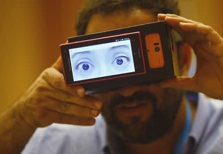 A visitor puts on "Truth?", a pair of goggles made by students from Keio University in Japan, that projects the "true emotions" of a person by monitoring the patterns of his or her heartbeat, during a design competition showcase of wearable technology at the Augmented Human International Conference in Singapore March 10, 2015. REUTERS/Edgar Su