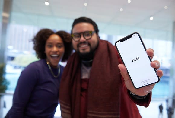 Apple customers holding the iPhone X on launch day