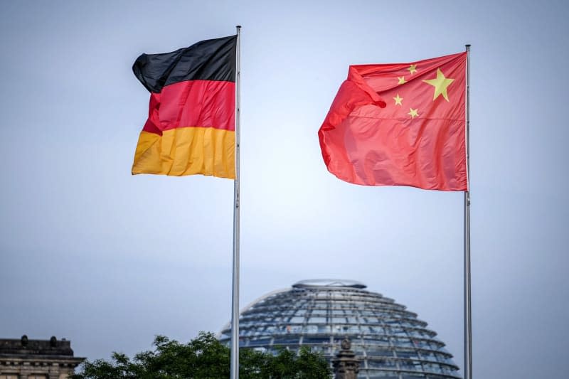 The flags of Germany and China wave in the wind in front of the Federal Chancellery. Three Germans have been arrested on suspicion of spying for the Chinese secret service, federal prosecutors said. Kay Nietfeld/dpa