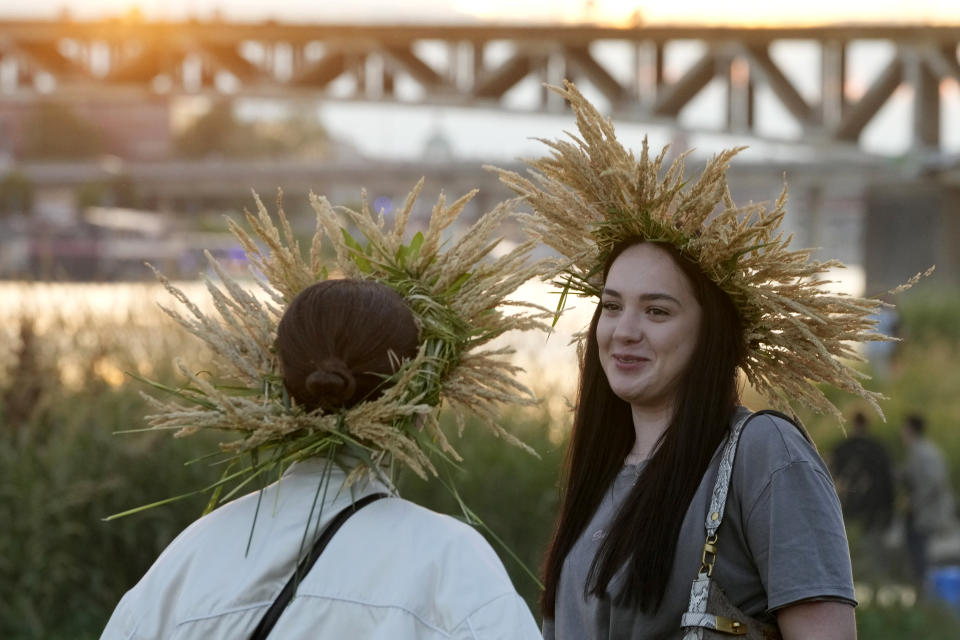 Young Ukrainian women wear ear of grain braids during a traditional Ukrainian celebration of Kupalo Night, in Warsaw, Poland, on Saturday, June 22, 2024. Ukrainians in Warsaw jumped over a bonfire and floated braids to honor the vital powers of water and fire on the Vistula River bank Saturday night, as they celebrated their solstice tradition of Ivan Kupalo Night away from war-torn home. (AP Photo/Czarek Sokolowski)