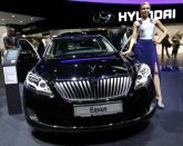 A model poses beside a Hyundai Equus car during a media preview day at the Frankfurt Motor Show (IAA) September 10, 2013. The world's biggest auto show is open to the public September 14 -22. REUTERS/Kai Pfaffenbach (GERMANY - Tags: BUSINESS TRANSPORT)