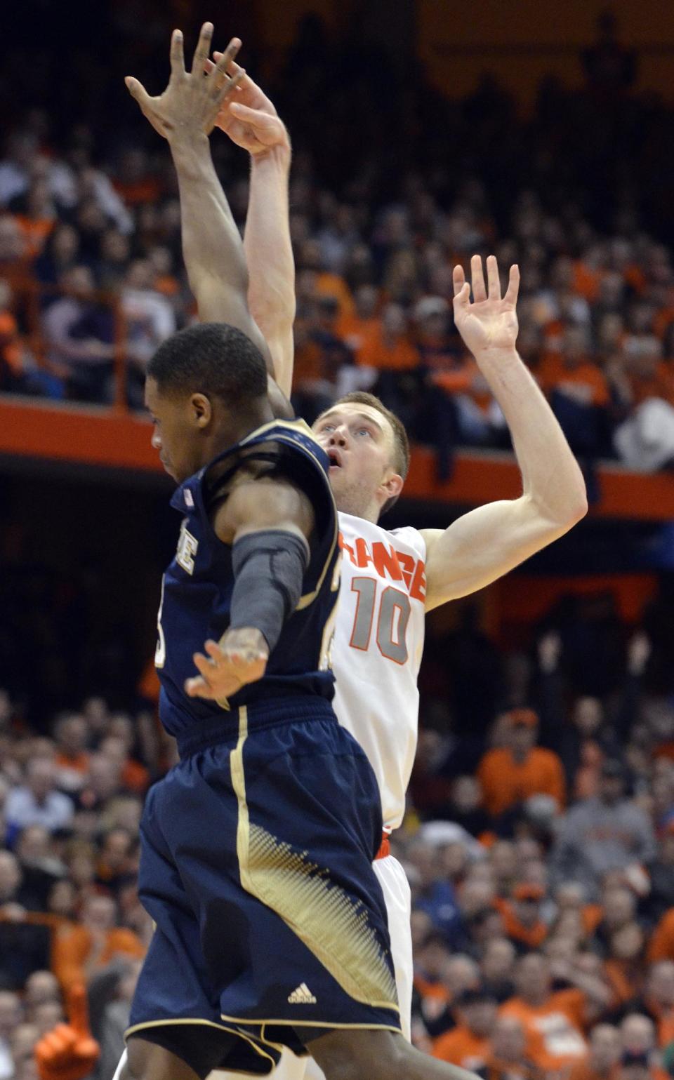 Syracuse's Trevor Cooney hits a three-point shot over Notre Dame's Demetrius Jackson during the second half of an NCAA college basketball game in Syracuse, N.Y., Monday, Feb. 3, 2014. Syracuse won 61-55. (AP Photo/Kevin Rivoli)
