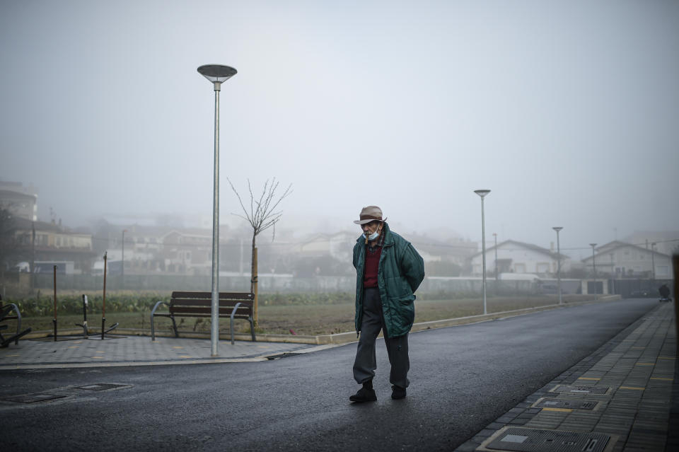 A resident walks early in the morning fog around at San Jeronimo nursing home in Estella, around 38 kms (23 miles) from Pamplona, northern Spain, Thursday, Jan. 28. 2021. (AP Photo/Alvaro Barrientos)