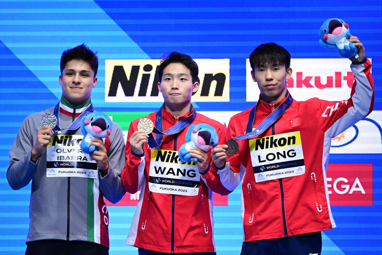 Osmar Olvera Ibarra (plata) posa junto a sus compañeros de podio en el Mundial de Fukuoka: los chinos Wang Zongyuan (oro), y Long Daoyi (bronce). (YUICHI YAMAZAKI/AFP via Getty Images)